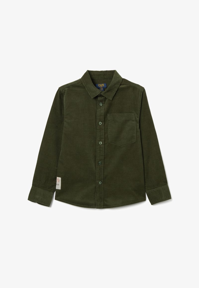 Camisa de pana de color verde oscuro con cuello de botón, mangas largas, bolsillo en el pecho y botones verdes. Presenta una pequeña etiqueta con el logotipo en un lado.