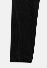 Black leggings featuring a textured pattern of interwoven lines, designed with a side pocket and a fitted cut for ease of movement.