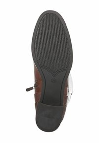 Bottine en cuir marron avec une semelle en caoutchouc noir texturé, fermeture éclair sur le côté et couture surélevée sur le dessus. Indicateur de taille visible.