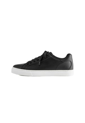 Baskets basses noires avec lacets noirs et semelle en caoutchouc blanche, vues de profil sur fond blanc.