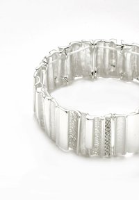 Pulsera de plata con segmentos estriados, superficies pulidas y texturizadas alternando, que presenta una fila de pequeñas piedras claras como acento.
