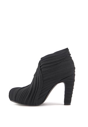 Botín de tacón alto negro hecho de tela texturizada con diseño plisado, punta redonda y tacón de aproximadamente 3 pulgadas.