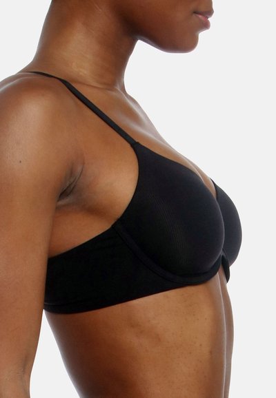 Sujetador inalámbrico negro con tirantes finos, textura suave y copa de forma redondeada; presenta un patrón sutil de canalé.