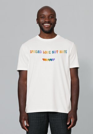 White cotton t-shirt with "SPREAD LOVE NOT HATE" text in colorful letters, featuring a rainbow heart graphic below, short sleeves, crew neckline.
