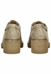 Beige ruskindssko med en rund tå og en kraftig sål. Har en glat tekstur og et minimalistisk design, med synlige stikningsdetaljer.