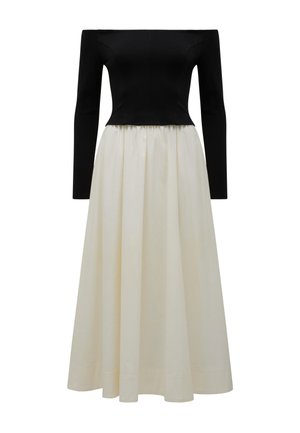 Off-shoulder black fitted long-sleeve top with a flowing high-waist white midi skirt dress.