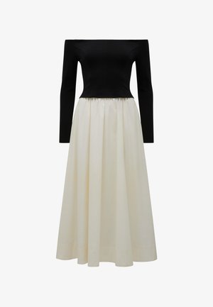 Off-shoulder zwarte aansluitende top met lange mouwen, gecombineerd met een vloeiende wit hoge taille midi jurkrok.