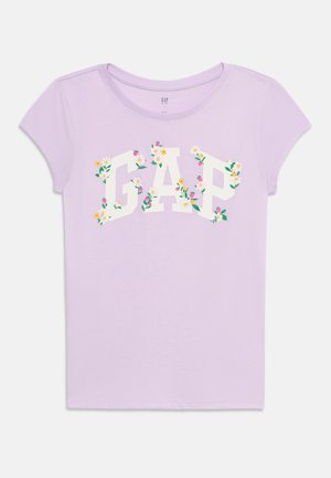 T-shirt a maniche corte di colore viola chiaro con la scritta "GAP" in grandi lettere bianche decorate con piccoli fiori colorati sul davanti.