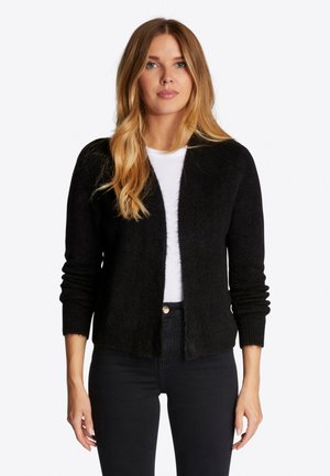 Cardigan negru tricotat, cu o textură moale, cu deschidere în față și mâneci lungi. Purtați peste un tricou alb, asortat cu blugi negri.