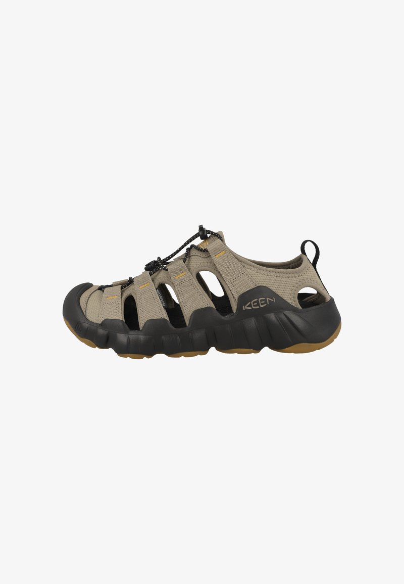 Beige Sandalen für den Außenbereich mit einem Obermaterial aus Mesh, schwarzer Gummisohle und verstellbarem Schnürverschluss. Verfügt über Aussparungen zur Belüftung und ein Logodetail.