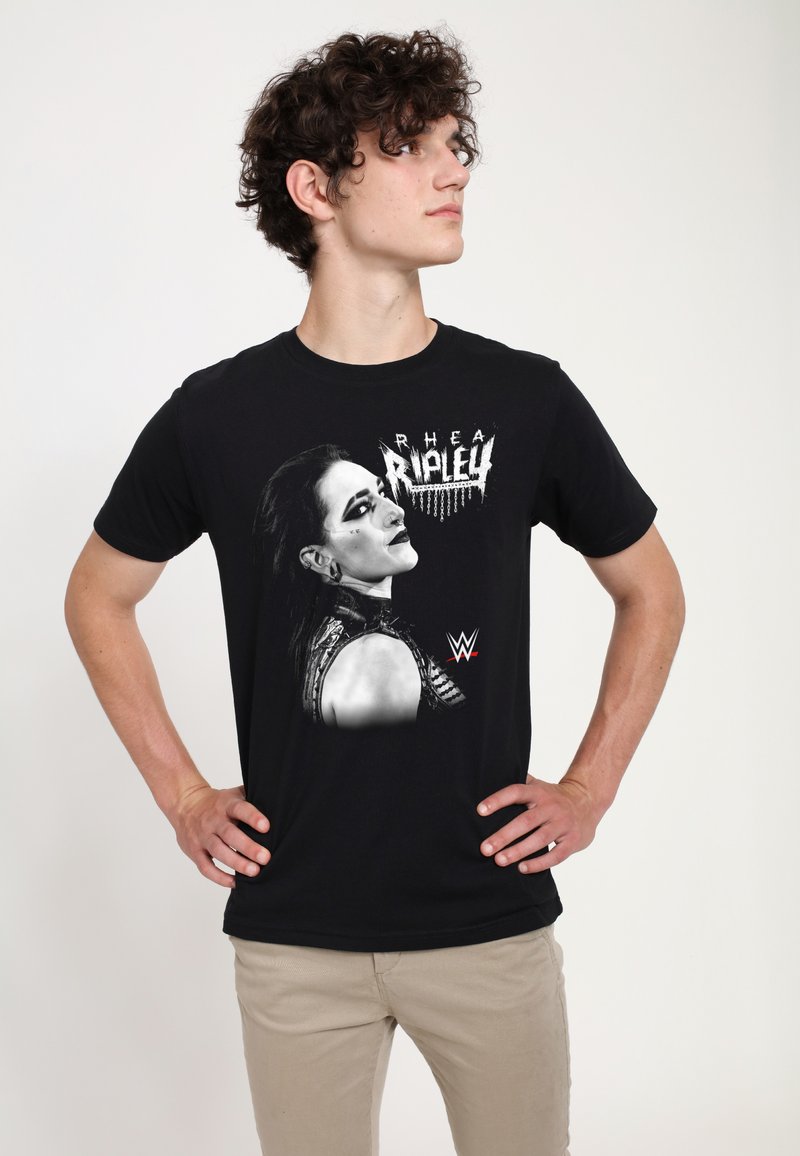 Sort bomulds T-shirt med grafik af en kvindes profil og teksten "RHEA RIPLEY" ovenover samt en rød WWE-logo nederst.