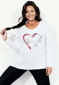 Biała koszula z długim rękawem, ozdobiona czerwonym sercem i wzorem płatka śniegu oraz napisem "It's Winter" w kolorze srebrnym. Miękki materiał, dekolt w kształcie litery V.