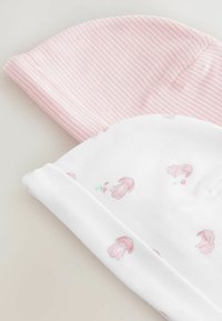 Dos gorros de bebé, uno a rayas rosas y otro en blanco con un patrón de conejitos, hechos de suave tela de algodón con bordes enrollados.