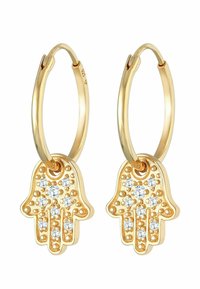 Boucles d'oreilles en or avec un pendentif en forme de main orné de cristaux transparents, présentant une surface lisse et brillante ainsi que des détails délicats.