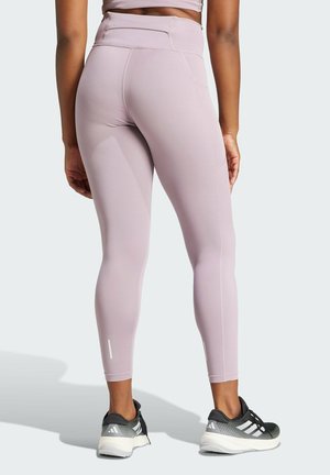 Leggings atletici di colore viola chiaro con vita alta, texture liscia e cuciture laterali sottili; abbinati a scarpe da corsa nere e grigie.