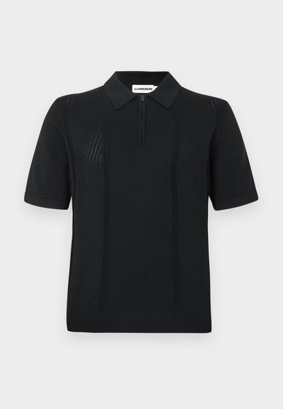 Polo preto de manga curta, com fecho de correr no decote, padrão texturizado nas laterais e bainha canelada. Feito de tecido respirável.