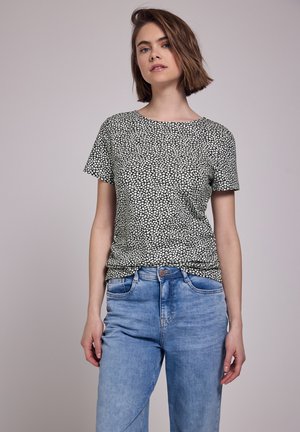 Top a maniche corte, con scollatura rotonda, in stampa floreale bianca e nera, abbinato a jeans a vita alta blu chiaro; materiale in misto cotone, vestibilità casual.