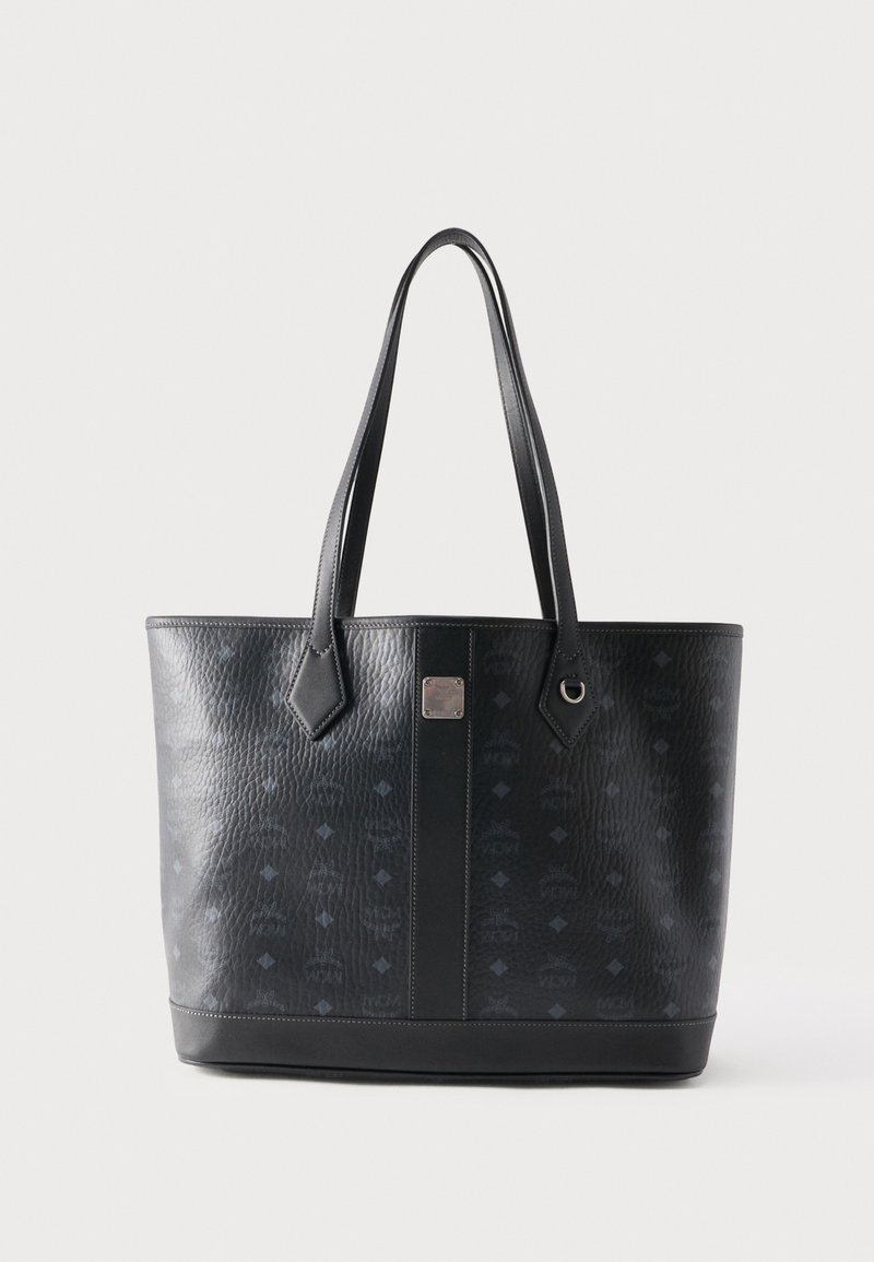 Sac fourre-tout en cuir noir avec motif texturé, deux longues poignées et une bande verticale centrale avec une petite plaque logo argentée.