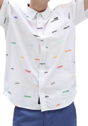 Camisa blanca de manga corta con patrones de texto multicolores de la palabra "amor" en varios idiomas. Con cuello abotonado y detalle de bolsillo.