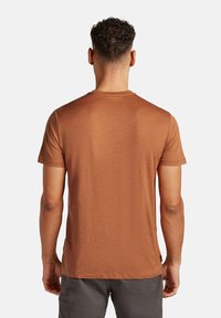 Korte mouwen t-shirt in een bruine tint, gemaakt van zachte stof met een gladde textuur; heeft een ronde halslijn en een klassieke snit.