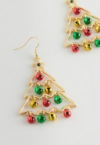 Goldfarbene Ohrringe in Form von Weihnachtsbäumen, verziert mit roten, grünen und gelben Glöckchen, und einem Stern-Detail an der Spitze.