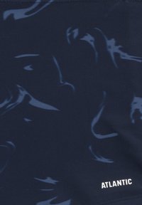 Granatowy materiał kąpielowy z abstrakcyjnymi jaśniejszymi wzorami, charakteryzujący się gładką teksturą oraz białym logo "ATLANTIC" w dolnym prawym rogu.