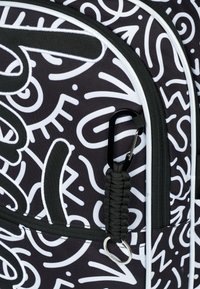 Zaino nero con motivi astratti bianchi, dotato di una superficie texturizzata, manico in corda nera e un gancio metallico per fissaggi.