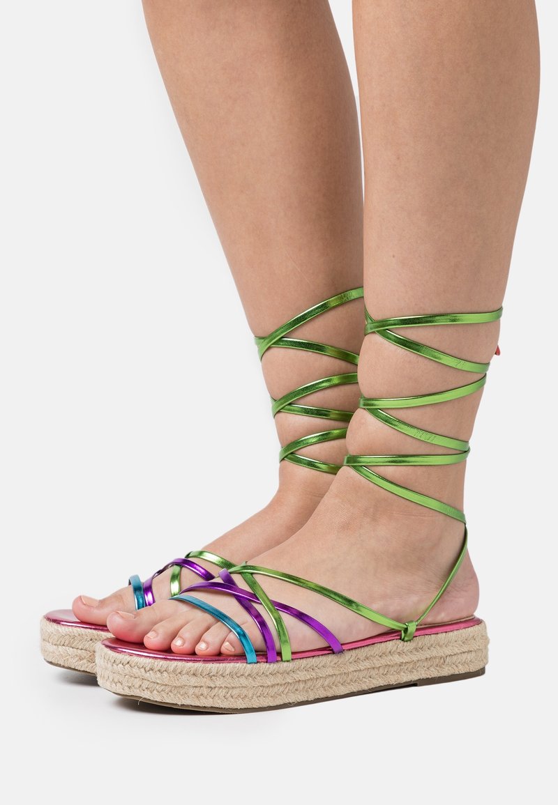 Sandales multicolores à brides avec des lanières métalliques vertes et violettes ; semelle intérieure réfléchissante rose ; semelle plateforme en jute tissé.