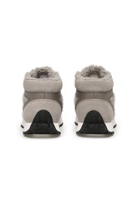 Sneakers grigie in suede con dettagli in finta pelliccia; collo imbottito, suola intermedia bianca e suola in gomma nera con un motivo a zigzag.