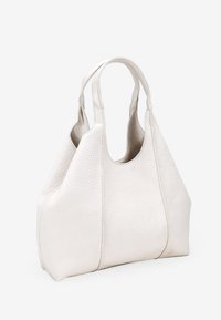 Bolso tote de cuero blanco con textura de piedras, dos asas curvas y una parte superior abierta y espaciosa. Presenta una textura suave y un diseño minimalista.