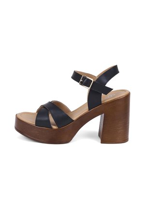 Sandale noire en cuir à brides avec boucle ajustable, talon haut épais en bois et semelle plateforme.
