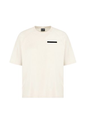 T-shirt a maniche corte di colore beige chiaro con scollatura a girocollo e un accento rettangolare nero sul petto. Tessuto liscio con una vestibilità rilassata.