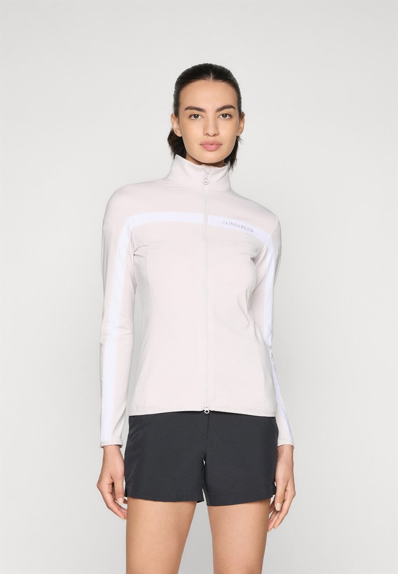 Lyserød zip-up jakke med høj krave og hvide striber. Blødt materiale, tætsiddende design, parret med sorte shorts. Brændlogo synligt.