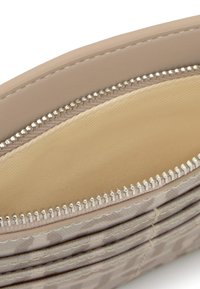 Portafoglio sintetico beige con finitura liscia e cerniera argentata. La fodera interna è in tessuto chiaro con una texture sottile. Presenta molteplici scomparti per carte.