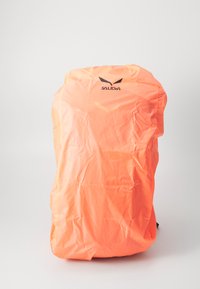 Oranssi vedenpitävä reppukansi, jossa on logo, suunniteltu suojaamaan reppuja sateelta ja kosteudelta. Sujuva, kevyt materiaali.