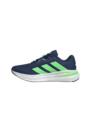 Zapatilla de correr azul marino con rayas verde neón, suela acolchada blanca y suela exterior negra, vista de perfil derecho.