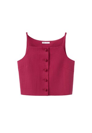 Mujer con el cabello recogido que lleva una camiseta roja sin mangas y pantalones a juego, adornada con múltiples pulseras doradas en la muñeca derecha.