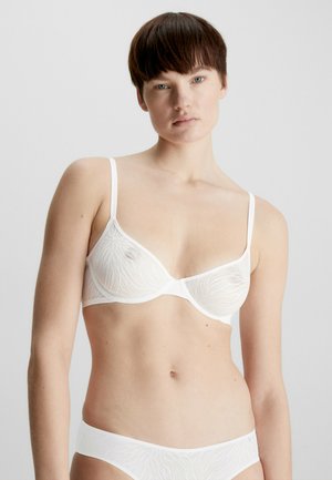Soutien-gorge blanc en tissu transparent avec un motif de feuilles, support en armature, bretelles réglables et texture douce et lisse.