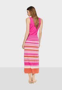 Prilagođena haljina bez rukava u ružičastoj boji s horizontalnim prugama u različitim nijansama, uključujući narančastu i krem, koja seže do sredine lista. Glatka tekstura.