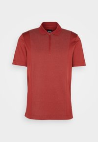 Polo rouge à manches courtes avec panneau avant texturé et col zippé jusqu'au quart, doté d'un col classique.