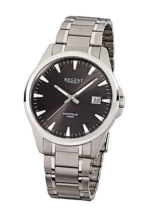 Montre-bracelet en métal argenté avec cadran noir, index horaires triangulaires blancs, affichage de la date à 3 heures, et trois aiguilles argentées indiquant 10:11:38.