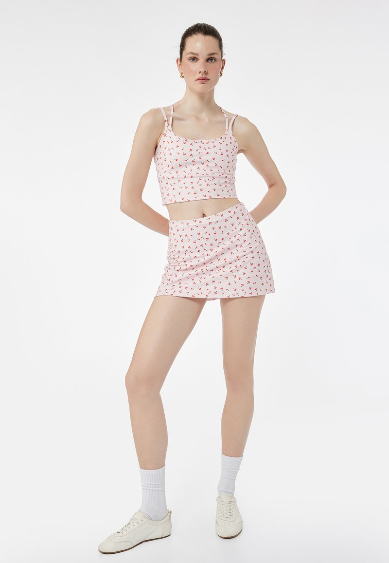 To-delt outfit bestående af en lyserød top og mini nederdel med et lille blomstermønster. Fremstillet af letvægtsstof, justerbare stropper.