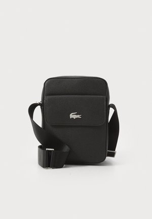Sac bandoulière noir texturé avec sangle réglable et poche avant à rabat ornée d'un petit logo crocodile argenté.
