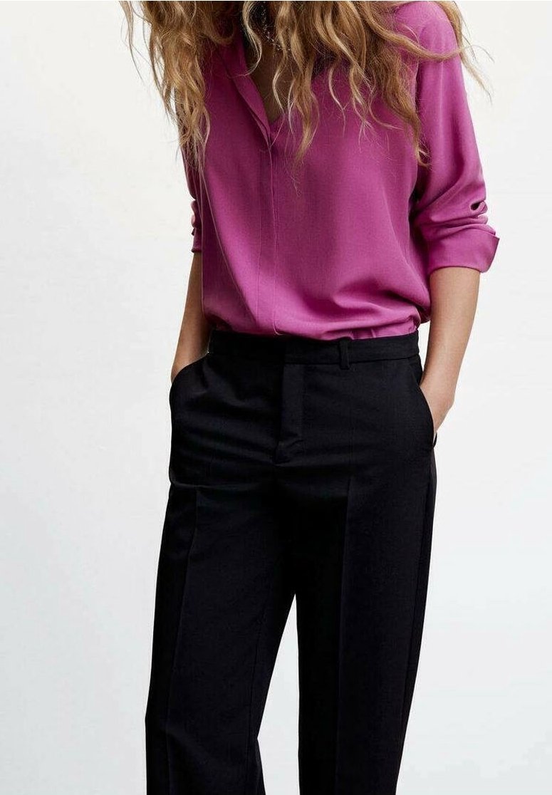 Fuchsia bluse med opkrøllede ærmer og V-hals, parret med sorte bukser med skræddersyet pasform og sidelommer.