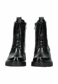 Par de botas de cuero negro con cordones, con cremalleras laterales y suelas de goma gruesa, mostradas de frente sobre fondo blanco.