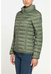 Giacca puffa verde oliva con trapuntatura orizzontale, colletto rialzato e tasche laterali con zip. Il materiale ha una finitura liscia e lucida.