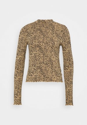 Długi top w panterkę w kolorze beżowym z czarnymi plamkami. Dopasowany fason z wysokim kołnierzem i falowanym wykończeniem na mankietach i dole. Miękki materiał.