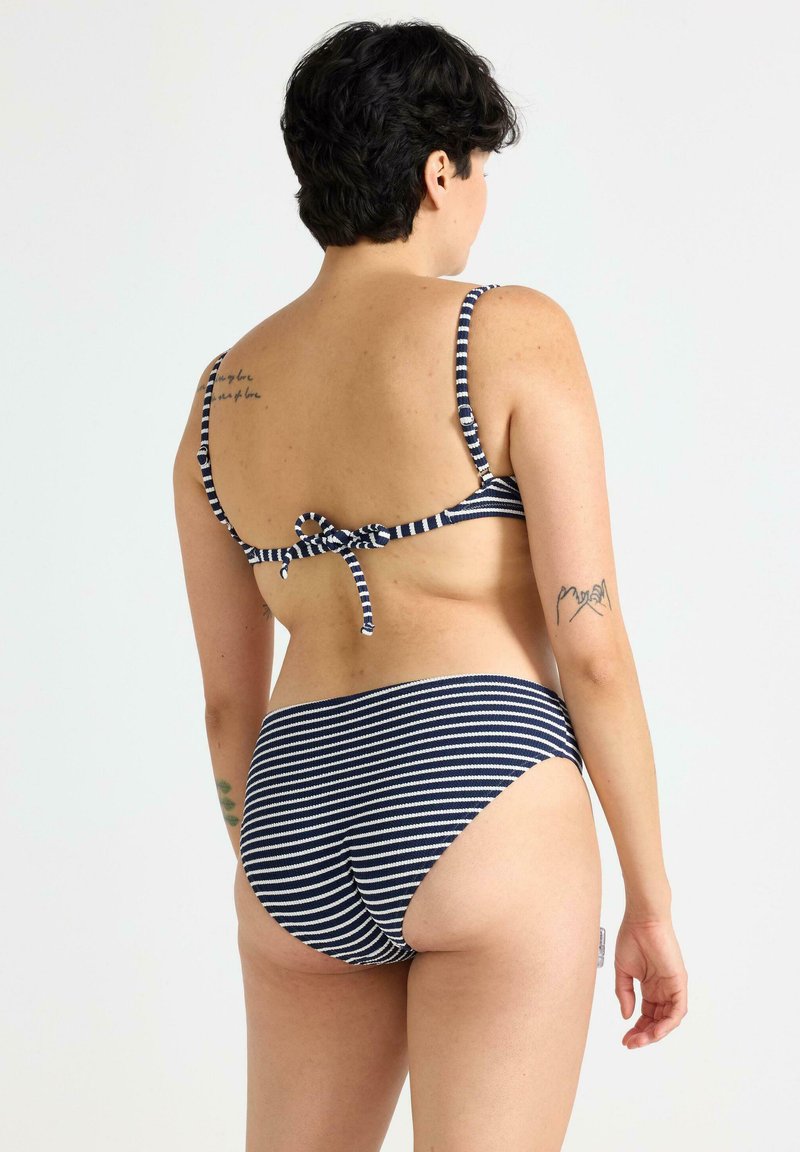 Marinblå och vitrandig bikini med justerbara spaghettistängar och knytning i ryggen, samt högmidjade bottoms.