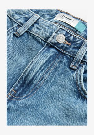 Jeans de mezclilla azul claro con un ajuste de altura media, corte recto, costuras de cobre y cierre de botón. Etiqueta de la marca visible en la parte interior de la cinturilla.