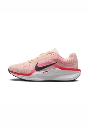 Chaussure de course Nike rose clair avec logo swoosh noir, accent rouge et semelle blanche rembourrée, vue de côté sur fond blanc.